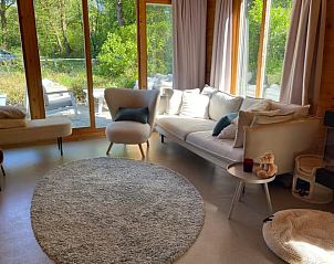 Open woon- en eetkamer in DG1871, vakantiehuis in Spier, Midden Drenthe met houten interieur.