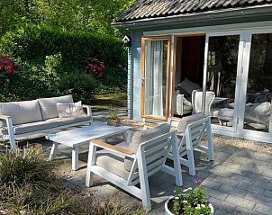 Zonnig terras van DG1871, vakantiehuis in Spier, Midden Drenthe met comfortabele stoelen.