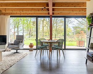 Eetruimte in Huisje in Spier met uitzicht op groene omgeving.