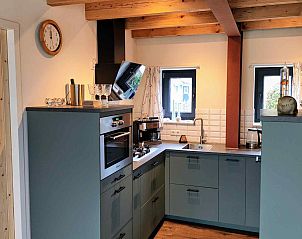 Stijlvolle hal in DG1552 vakantiehuis, Spier, Drenthe, met kunst aan de muur en modern meubilair.