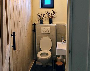 Moderne badkamer in DG1552 vakantiehuis, Spier, Drenthe, met dubbele wastafel en houten schuifdeur.