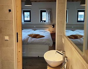 Zonnig terras van DG1552 vakantiehuis in Spier, Drenthe, met uitzicht op besneeuwde natuur.