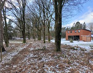 Gezellige woonkamer in DG1552 vakantiehuis, Spier, Drenthe, met houtkachel en comfortabele zithoek.