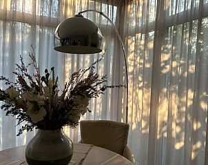 Gezellige eethoek in Huisje in Spier, een vakantiehuis in Midden Drenthe, Drenthe, met sfeervolle verlichting.