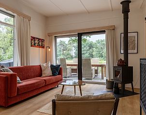 Gezellige eetkamer in vakantiehuis DG1812 in Spier met uitzicht op tuin.