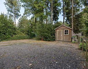 Zonnig terras bij vakantiehuis DG1812 in Spier met parasol en tuintafel.
