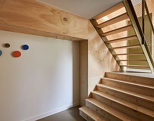 Houten trap en moderne inrichting in Vakantiehuis in Spier, een stijlvol verblijf in Midden Drenthe.