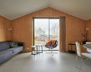 Gezellige woonkamer met uitzicht op de tuin in Vakantiehuis in Spier, Drenthe.