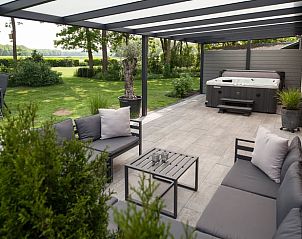 Relax on the veranda of Holiday Home in Schoonloo, Middle Drenthe, with comfortable patio furniture and views of green nature.