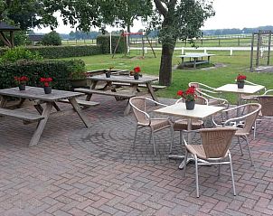 Gezellig terras met zitplaatsen en uitzicht op natuur in Vakantiehuis in Grolloo, Drenthe.
