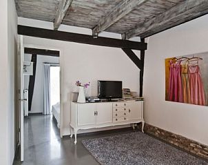 Gemtliche Sitzecke in De Schaapskooi, Drijber, mit moderner Einrichtung und Kunst an der Wand, perfekt fr einen Urlaub in Drenthe.