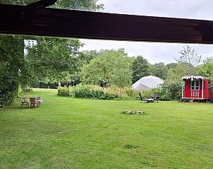 Uitzicht op groene tuin vanuit Vakantiehuisje in Orvelte, Midden Drenthe met ruime grasvelden.