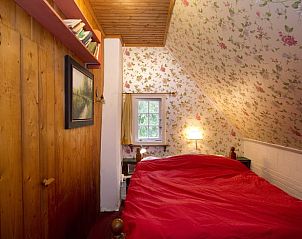 Slaapkamer met bloemenbehang in Huisje in Rolde, een charmant vakantiehuis in Midden Drenthe, Drenthe.