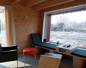 Gezellige binnenruimte van Vakantiehuis in Gasselte, Drenthe, met panoramisch uitzicht op de natuur vanuit een comfortabele zithoek.