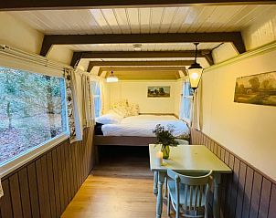 Cozy indoor area of Huisje in Papenvoort, a vacation home in Central Drenthe, with cozy dining area and views of nature.