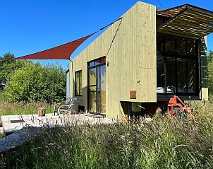Moderne architectuur van Huisje in Mantinge, een vakantiehuis in Midden Drenthe, met een uitnodigend terras en groene omgeving.