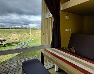 Uitzicht vanuit Vakantiehuisje in Mantinge, Drenthe, met terras en uitgestrekte groene velden.
