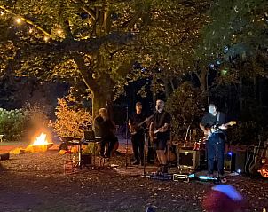 Avondentertainment bij Huisje in Mantinge, vakantiewoning in Drenthe, met live muziek onder sfeervolle verlichting.