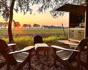 Zonsondergang bij het terras van Vakantiehuisje in Mantinge, Midden Drenthe, met uitzicht op de natuur.