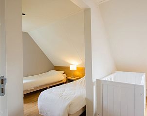 Sfeervolle slaapkamer in Hof van Saksen 10-persoons boerderij 10C, Nooitgedacht, Drenthe, met twee bedden.
