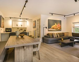 Stijlvolle eetkamer in Hof van Saksen 4-persoons Wellnessboerderij, Nooitgedacht, Drenthe, met houten tafel en comfortabele stoelen.