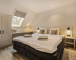 Slaapkamer met ensuite badkamer in Hof van Saksen 18-persoons boerderij, Nooitgedacht, Drenthe voor privacy en comfort.
