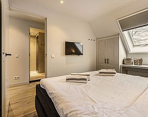 Moderne badkamer in Hof van Saksen 18-persoons boerderij, Nooitgedacht, Drenthe met inloopdouche en ronde spiegel.