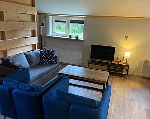 Ruime leefruimte in Vakantiehuisje in Odoorn, Midden Drenthe, met zithoek en uitzicht op de tuin.