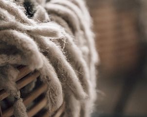 Detail van een zachte deken in Vakantiehuis in Odoorn, Midden Drenthe, voor een knusse sfeer.