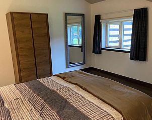 Lichte slaapkamer in Vakantiehuis in Odoorn, Drenthe, met grote kast en spiegel.