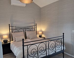 Sfeervolle slaapkamer in vakantiehuis DG2033, Odoorn, Midden Drenthe, met een elegant bed en zachte verlichting.