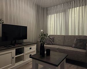 Gezellige woonkamer in vakantiehuis DG2033, Odoorn, Midden Drenthe, met comfortabele bank en televisie.