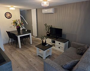 Eet- en zithoek in vakantiehuis DG2033, Odoorn, Midden Drenthe, met elegante meubels en decoratie.