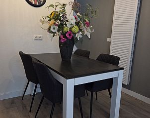Eettafel met bloemen in vakantiehuis DG2033, Odoorn, Midden Drenthe, ideaal voor gezellige maaltijden.