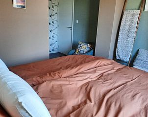 Knusse slaapkamer met warme kleuren in Vakantiehuisje in Wezup, Midden Drenthe.