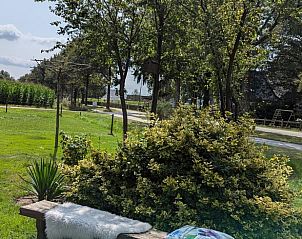 Gezellig bankje in de tuin van Vakantiehuisje in Wezup, ideaal voor ontspanning.