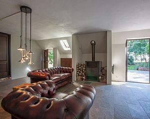 Gezellige woonkamer met leren banken in Vakantiehuis in Peize, Noord Drenthe.