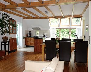 Ruime binnenruimte van Huisje in Peize, Noord Drenthe, met houten vloer en eetgedeelte.