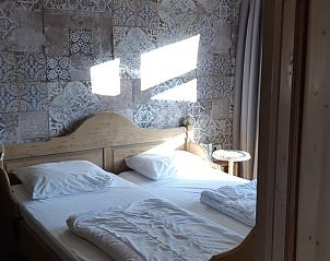 Slaapkamer in Huisje in Een, vakantiehuis in Noord Drenthe, met rustieke decoratie en comfortabele bedden.