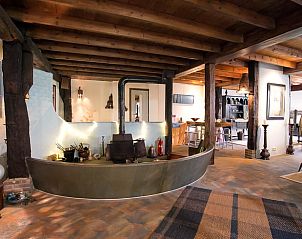 Rustieke binnenruimte van Huisje in Een, vakantiehuis in Noord Drenthe, met authentieke houten balken en open haard.