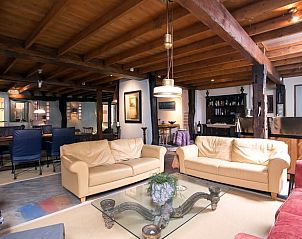 Stijlvolle zithoek in Huisje in Een, vakantiehuis in Noord Drenthe, met kunstwerken en warme kleuren.