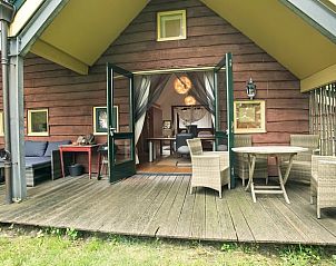 Vakantiehuis in Een, Noord Drenthe, met uitnodigende veranda en comfortabele buitenmeubels.