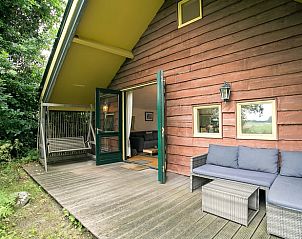 Gezellig terras van Vakantiehuis in Een, Noord Drenthe, met comfortabele zitplaatsen en groene omgeving.