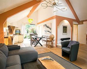 Lichte en ruime woonkamer in Vakantiehuis in Een, Noord Drenthe, met comfortabele meubels en kunst aan de muur.