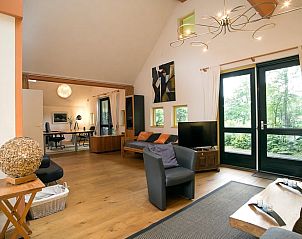 Woonkamer in Vakantiehuis in Een, Noord Drenthe, met moderne inrichting en toegang tot de tuin.