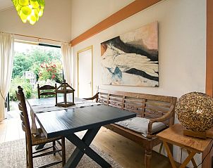 Eetkamer in Vakantiehuis in Een, Noord Drenthe, met houten meubels en uitzicht op de tuin.