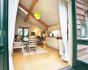 Open keuken en eetruimte in Vakantiehuis in Een, Noord Drenthe, met toegang tot de buitenruimte.