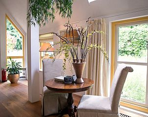 Knusse zithoek in Vakantiehuisje in Een, Noord Drenthe, met uitzicht op de groene tuin.