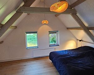 Ruime slaapkamer in Huisje in Een, een vakantiehuis in Noord Drenthe, met houten balken.