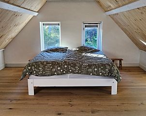 Zolderkamer met houten vloer in Huisje in Een, een vakantiehuis in Noord Drenthe.